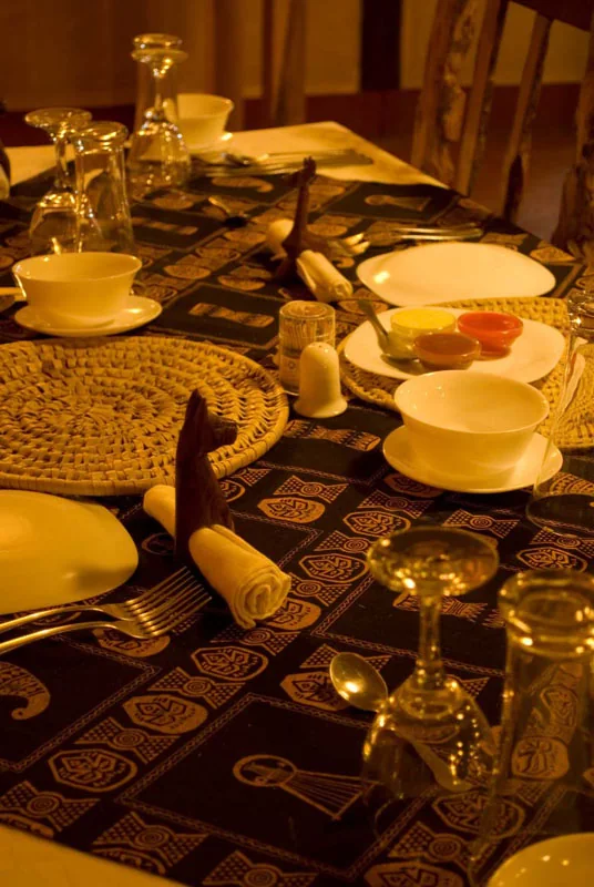 A dinner table laid with yellow crockery and glassware