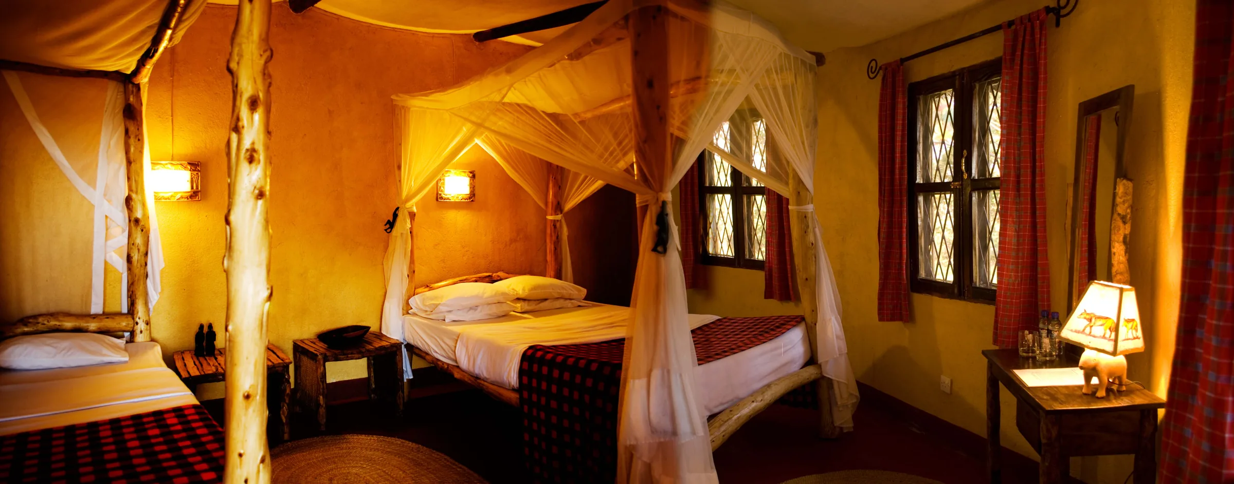 The family cottage, with a four-poster double bed and a single bed under mosquito nets