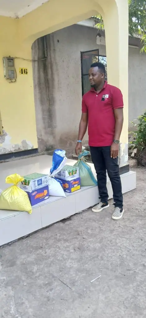 A man standing beside sacks and boxes on a verandah step