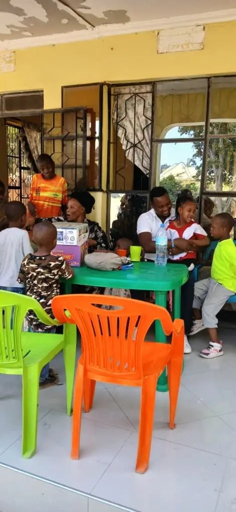 Children and adults sitting together around a table on a verandah
